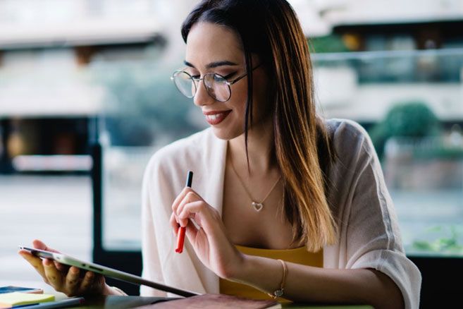 Woman working on tablet at cafe